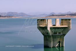 Image du Maroc Professionnelle de  Le barrage Oued El Makhazine, conçu pour le développement et  l'irrigation du périmètre du Loukkos. Ainsi les champs situés dans le triangle Ksar El Kébir, Larache, Moulay Bouselham profitent de cette infrastructure. Cette importante réalisation située sur El Oued Loukkos sert à la régularisation inter annuelle des débits tout en formant une protection contre les crues, au Jeudi 1er Septembre 2005 à cette datte le barrage dispose 309 Million de M3. (Photo / Abdeljalil Bounhar) 